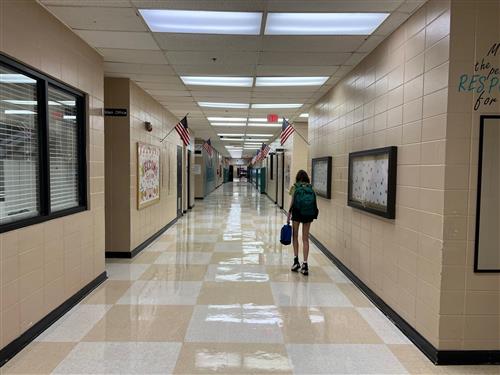 lone student walking in quiet  hallway 